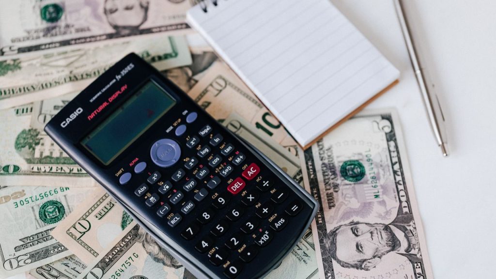 Coach bepaalt prijs voor online cursus met calculator en laptop