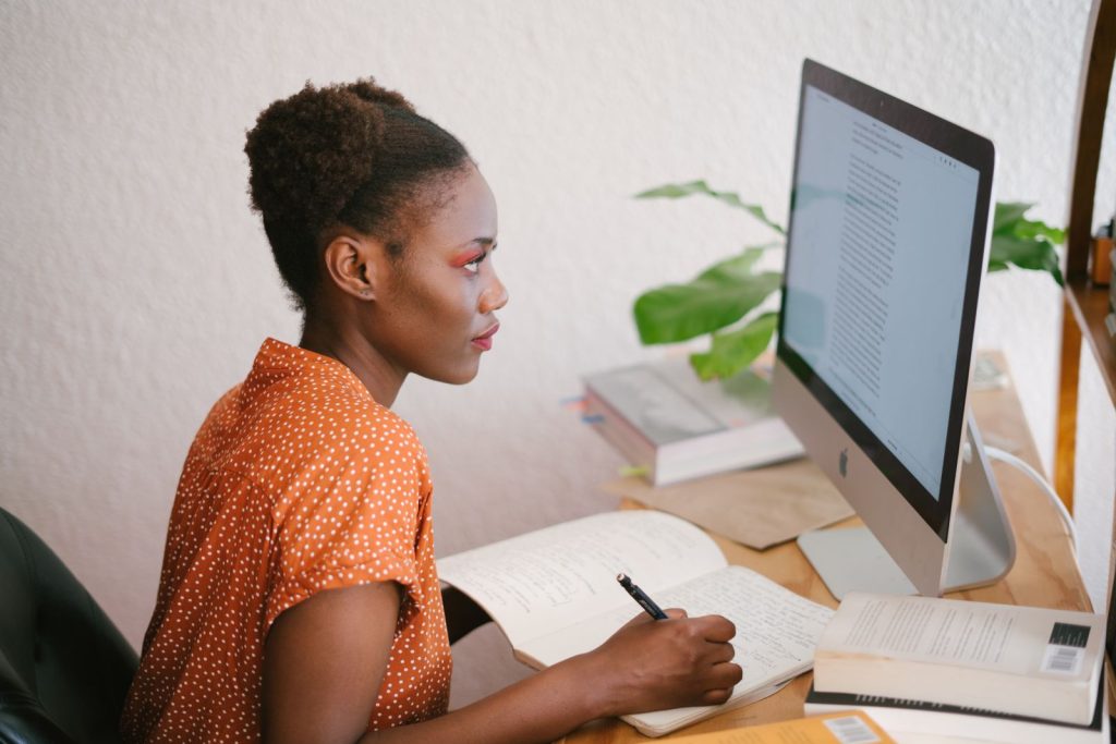 Vrouw vergelijkt e-learning platforms op laptop voor online cursus